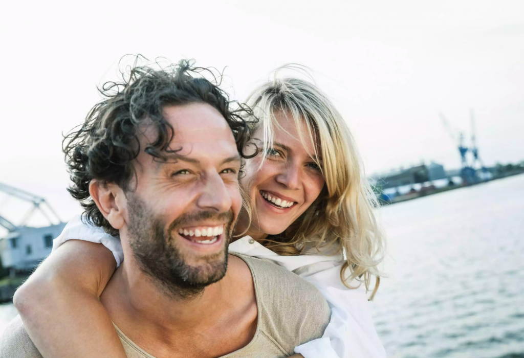 Lachendes Paar vor Hafenkulisse