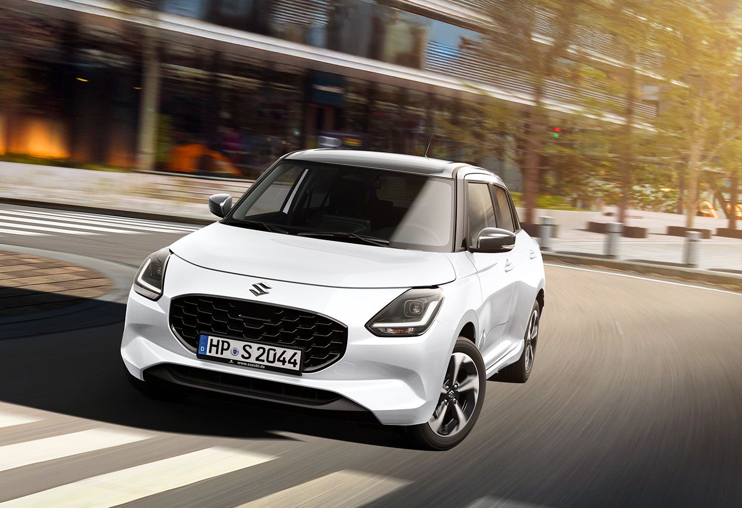 Weißer Suzuki Swift 1.2 DUALJET HYBRID Comfort+ vor City-Setting und Restaurant-Außenbereich in Front-Seitenansicht